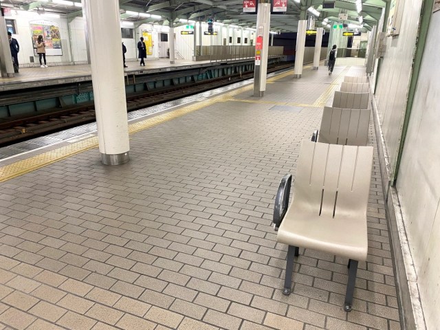 Why do seats at some Japanese station platforms face away from the trains?