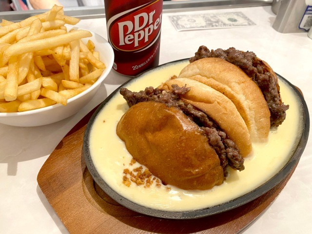 Burgers soaked in a plate of hot cheese served at American Diner Andra in Tokyo